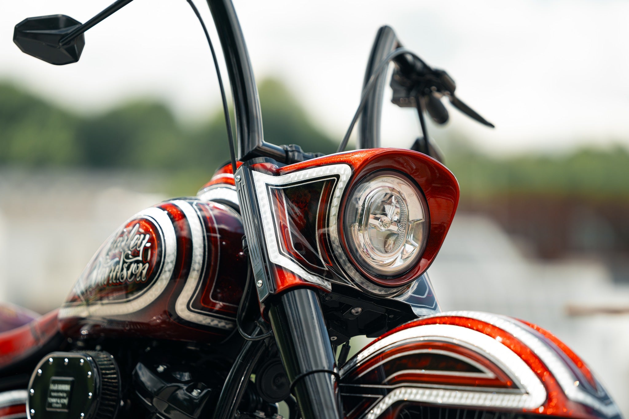 Close-up of a motorcycle's headlight and handlebar with a blurred background