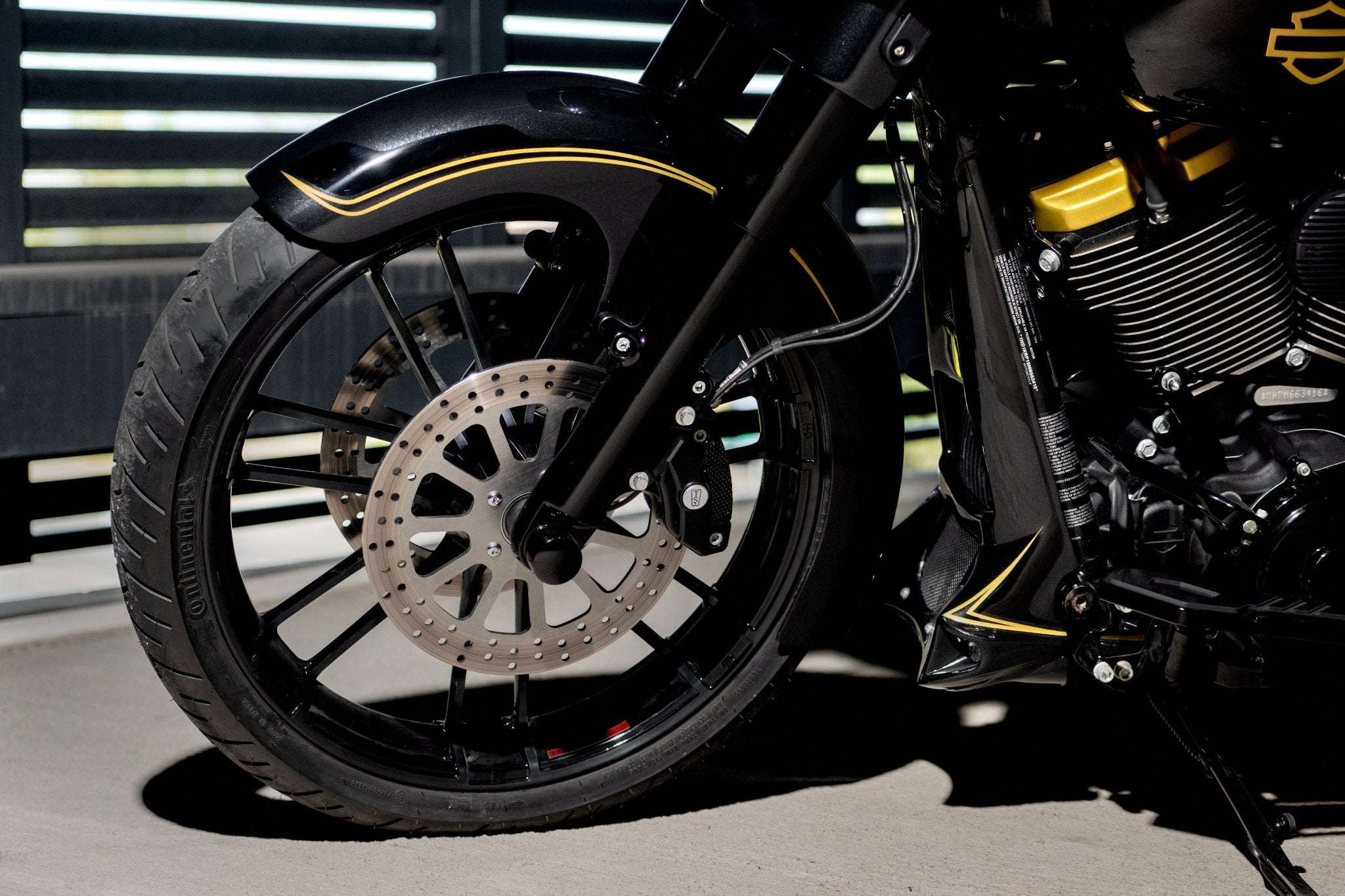 21" custom front wheel mounted on a Harley Davidson Street Glide 2021 with wrapper style Tommy&Sons front fender and custom radiator cover. Photographed upclose.