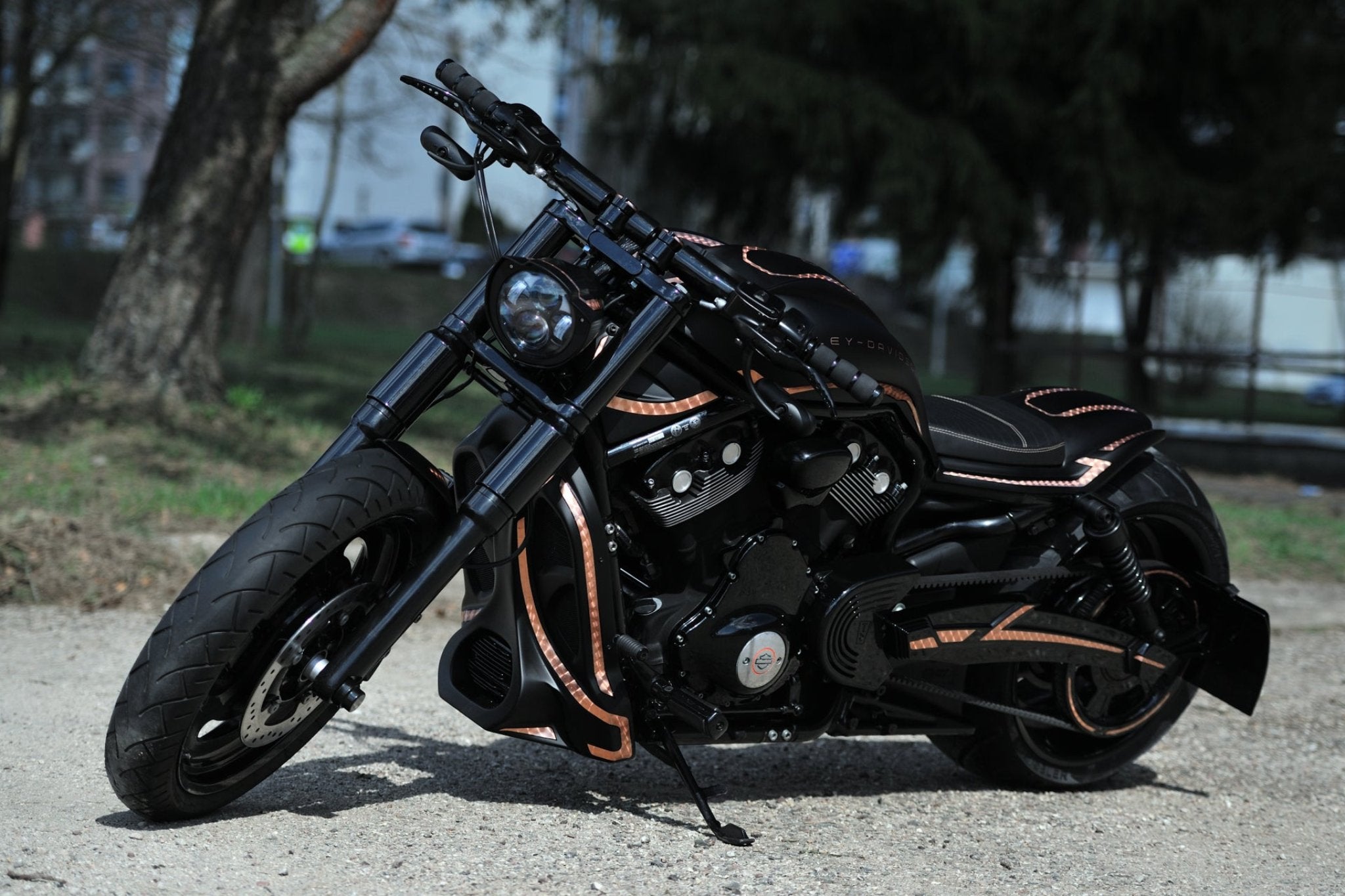 Custom Harley Davidson V-Rod Night Rod with body kit by Tommy&Sons painted in black with copper stripes, photographed from the front. 