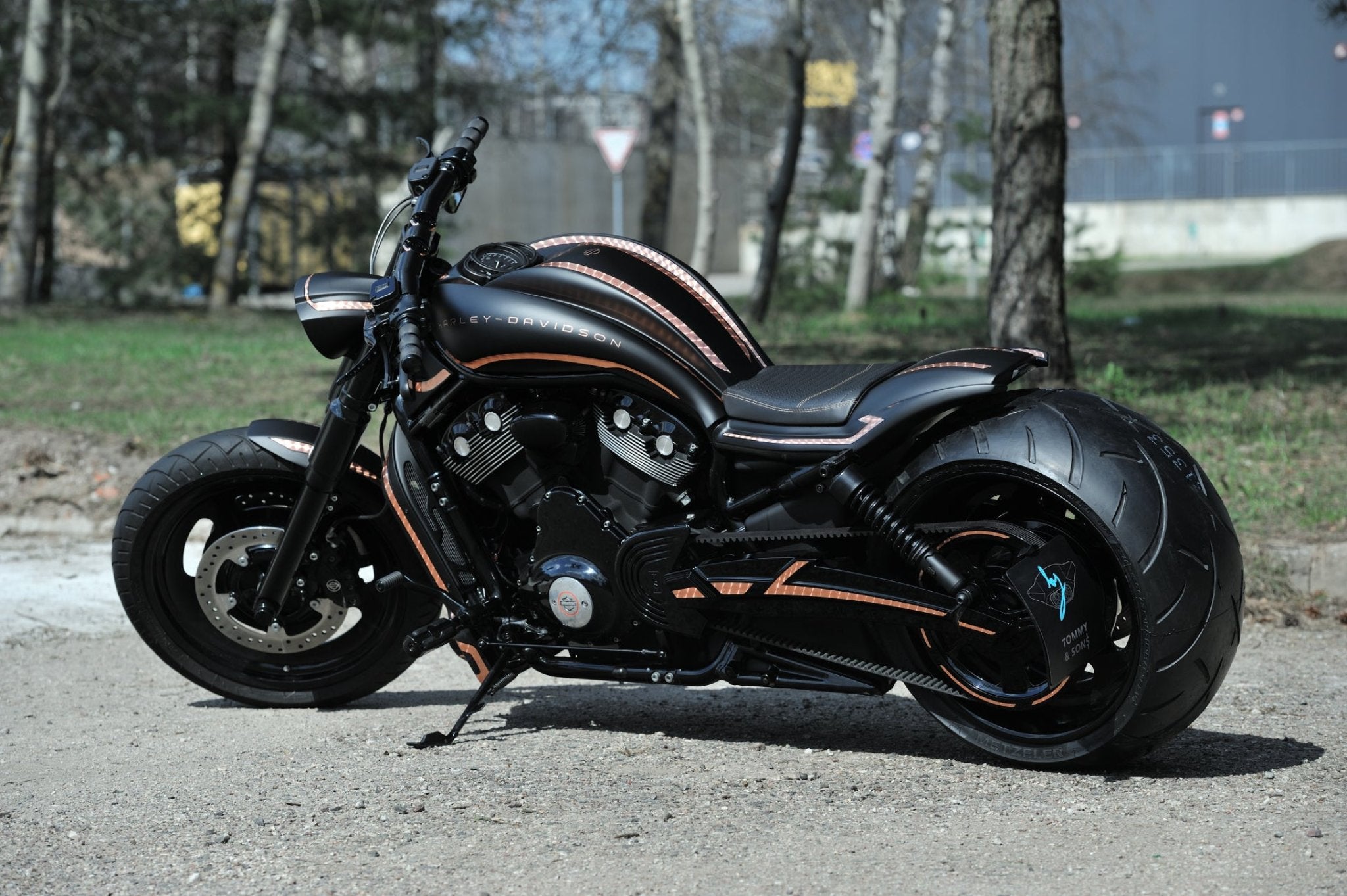 Custom Harley Davidson V-Rod with full aftermarket body kit and 300 rear wheel photographed from the rear left side.