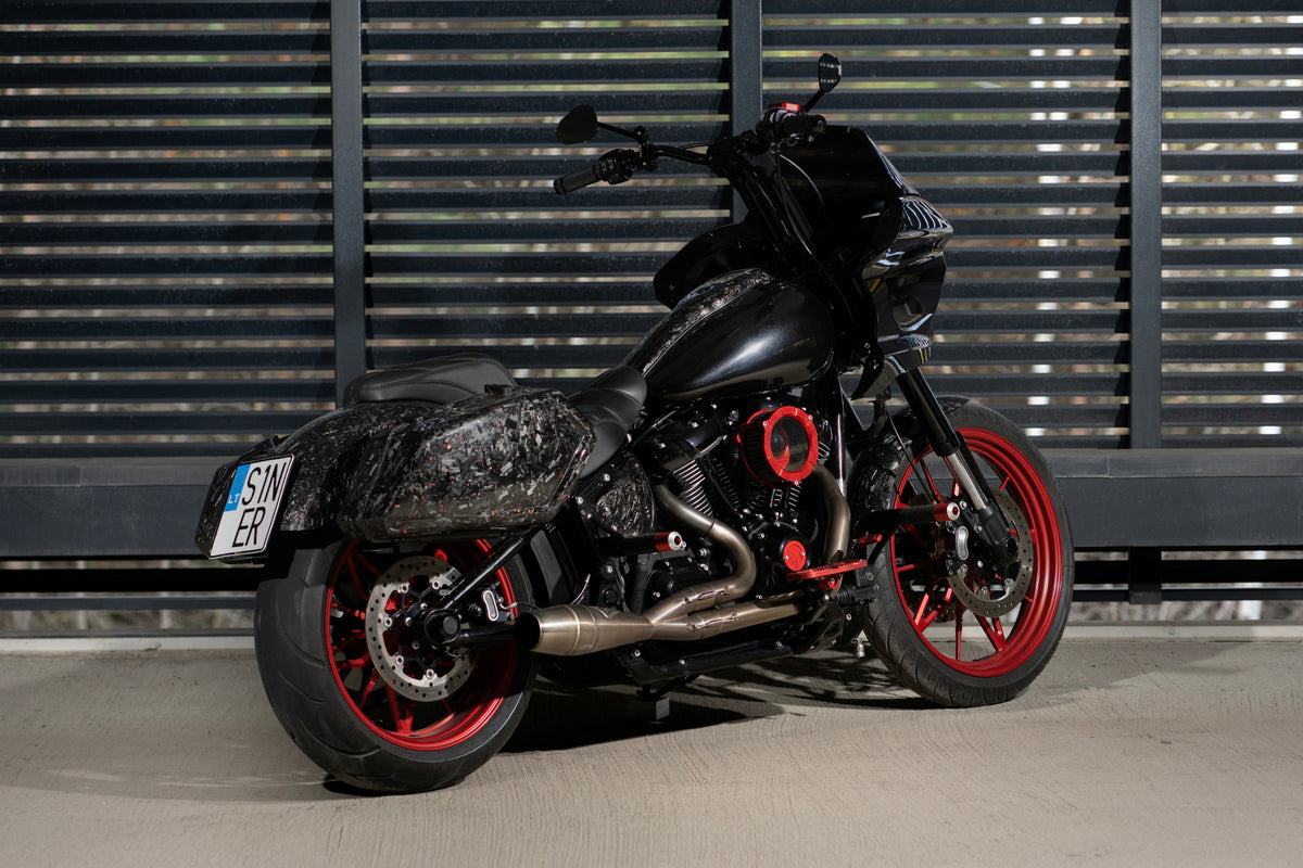 Exhaust-side view of Forged Sinner V2 featuring Inception forged carbon fiber saddlebags, red wheels and custom exhaust.